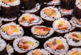 Fototapeta Kwiaty - Top view of stack of Japanese sushi maki roll plate. Served in Japanese bar restaurant with chopstick
