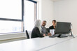 © Mangostar - Boss and managers analyzing reports and discussing work. Team sitting together at workplace with monitors, papers and talking. Copy space. Business meeting concept