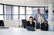 © Mangostar - Business team of three watching presentation on pc monitor, discussing project, sitting at workplace and pointing at display. Copy space. Business meeting concept