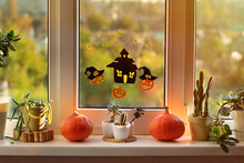 Happy Halloween! The Window Of A House Decorated For The Holiday. Halloween Decorations On Window: Pumpkins, Stickers Of Smiling Jack And Scary House.