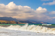 Hohe Wellen am Badestrand vor dem Bergland im Westen Kretas im Abendlicht