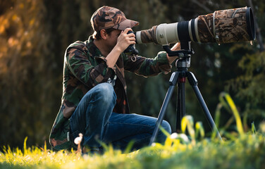 wildlife photographer using telephoto lens with camouflage coating photographing wild life using gim