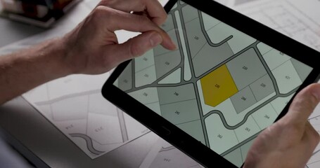 Wall Mural - choosing building plot for sale on cadastral plan for house construction on digital tablet. slider s
