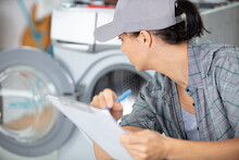 Young Woman Repairing A Washing Machine