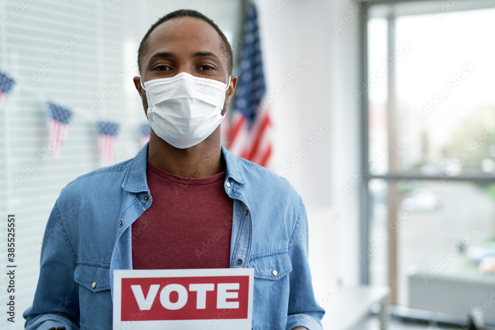 Black man in face mask with voting card - obrazy, fototapety, plakaty 