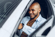 © fotofabrika - Portrait of a handsome happy African American man sitting in his newly bought car