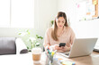 © AntonioDiaz - Businesswoman using a smartphone in an office