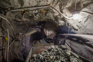 Wagons minecarts with gol ore in underground mine tunnel