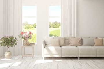 Wall Mural - White living room with sofa and summer landscape in window. Scandinavian interior design. 3D illustration