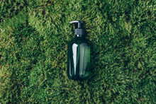 Unlabelled Cosmetic Bottle On Green Moss Background. Biophilic Design. Skin Care, Organic Body Treatment, Spa Concept. Vegan Eco Friendly Cosmetology Product. Organic Cosmetics.