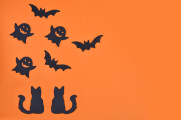 Wall Mural - Happy Halloween! Pumpkin, bats, cat, ghost on an orange background and a glowing bokeh background. Copy space for text