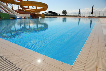 Poster - Outdoor swimming pool with clear water on sunny day. Summer vacation