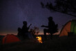 © New Africa - Silhouettes of couple near bonfire in evening. Camping season