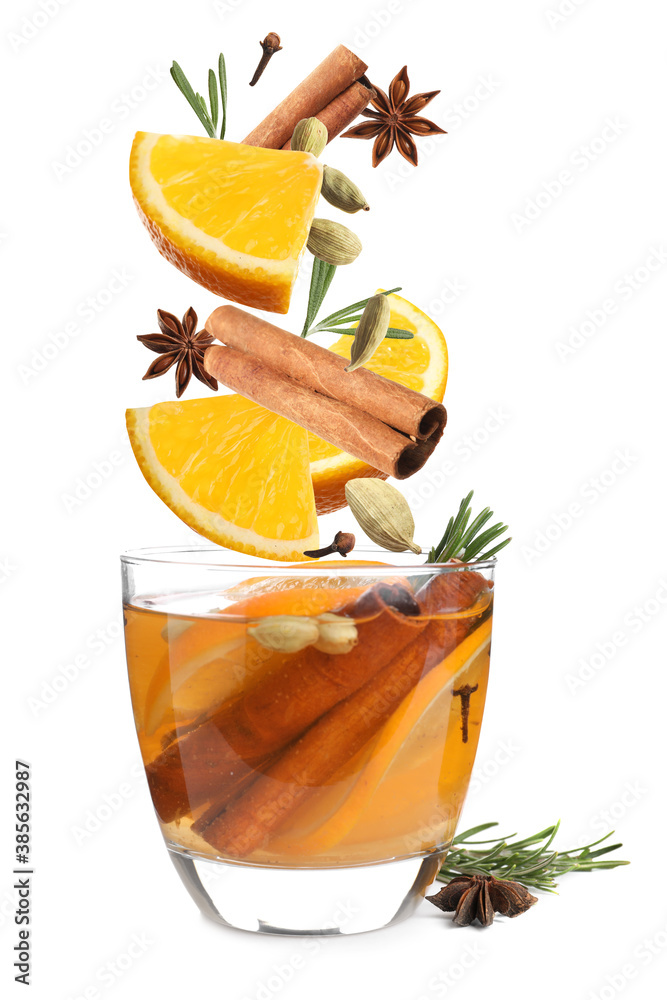Cut orange and different spices falling into glass of mulled wine on white background - obrazy, fototapety, plakaty 