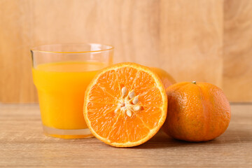 Fresh Honey Murcott orange fruit and juice on wooden background