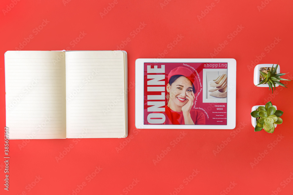 Tablet computer and notebook on color background. Online shopping concept
