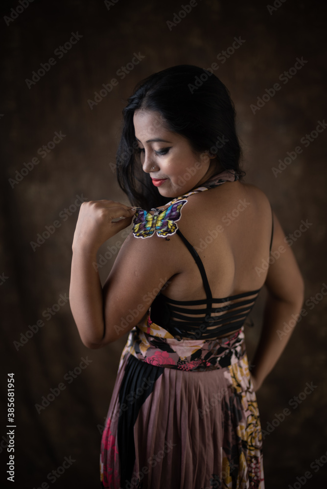 Photo Stock Studio portrait of an young Indian girl in western backless  dress in front of textured background. Fashion portrait photography | Adobe  Stock