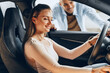 © fotofabrika - Joyful young couple looking around inside a new car they are going to buy in a car shop