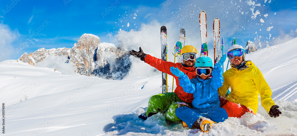 Skiing family enjoying winter vacation on snow in sunny cold day in mountains and fun. San Martino di Castrozza, Italy. - obrazy, fototapety, plakaty 
