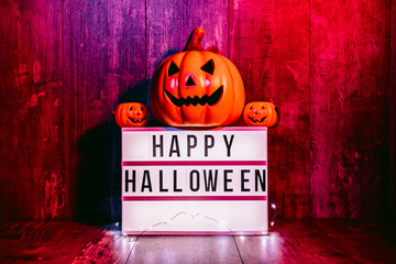 Light box with 'Happy Halloween' message and small pumpkins with blue and red atmosphere