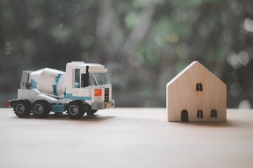 Wall Mural - Concrete mixer truck plastic toy and miniature wood home.