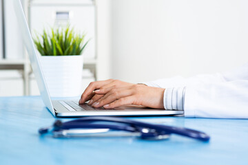 Close up of female doctor hands with laptop