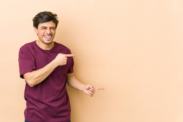 Wall Mural - Young cool man pointing with forefingers to a copy space, expressing excitement and desire.