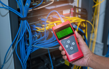 Network tester tools and system administrators will test the network cable in technogy data center room.