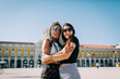 © Alexandra C. Ribeiro/Westend61 - Women embracing each other at Praca Do Comercio against clear sky, Lisbon, Portugal