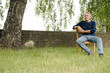 © KNSY/Westend61 - Contemplating man sitting on chair against brick wall in backyard