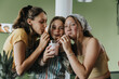 © Mareen Fischinger/Westend61 - Teenage girls standing in kitchen sharing fresh fruit smoothie with drinking straws