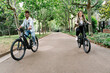 © Roger Diaz Gomez/Westend61 - Happy young couple riding electric bicycles on road amidst trees