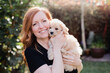 © Nicole Matthews/Westend61 - Beautiful woman with cute dog at back yard