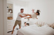 © Sara Monika/Westend61 - Playful father throwing daughter over bed while son sitting in bedroom
