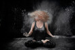 © victor espadas gonzalez/Westend61 - Woman tossing hair covered in white dust while sitting against black background