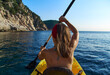 © Anna Mensa/Westend61 - Woman kayaking while sitting in boat against clear sky