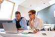 © Vasily Pindyurin/Westend61 - Confident male and female entrepreneurs looking at laptop while planning strategy in office