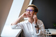 © Vasily Pindyurin/Westend61 - Smiling businesswoman talking on mobile phone while looking through window in office cafeteria