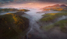 Scenic View Of Fog Over Hills During Sunrise