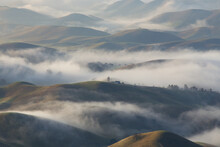 Scenic View Of Fog Over Hills During Sunrise