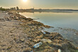 © Olena Shvets - Landscape of polluted with plastic garbage shore of the lake on the sunset. Environmental disaster concept