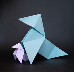 origami birds family protection - two paper birds on a black background