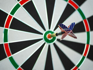 Dart arrow with tail of USA flag backgroun hitting in the target center of dartboard. Bullseye is a target of business. The concept of a successful strategy and business marketing.