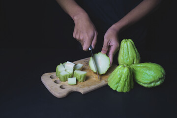 Wall Mural - Chayote squash or Mirlition squash cutting by kitchen knife preparing for cooking, organic vegetable, edible plant fruit                