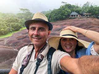 Poster - Happy couple wearing hats and smiling in a tropical island excursion with rain