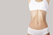 © Alena - flat belly and slender figure of a woman. Grey background. copycpase