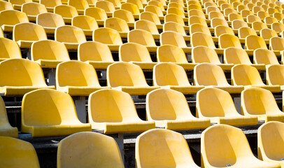 yellow tribunes. seats of tribune on sport stadium. empty outdoor arena. concept of fans. chairs for