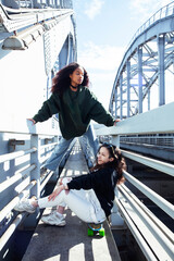 Wall Mural - young cute teenage girls together in industrial zone happy smiling having fun, big city lifestyle fashion people