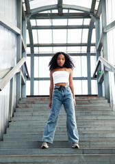 Wall Mural - young cute teenage african girl in industrial zone happy smiling having fun, big city lifestyle fashion people