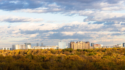 Wall Mural - panoramic view of urban park and residential district on horizon lit by autumn sunset sun in Moscow city